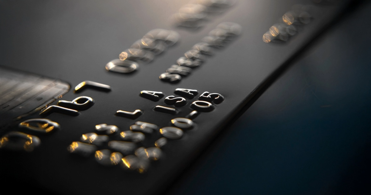 Consumidor segurando cartão de crédito não solicitado junto ao contrato de empréstimo